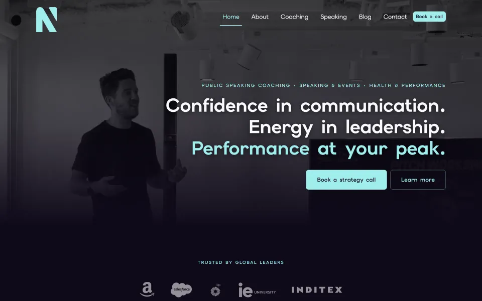 Nick Hampshire homepage hero: a dark stage-lit photograph of Nick mid-talk beside the headline 'Confidence in communication. Energy in leadership. Performance at your peak.'