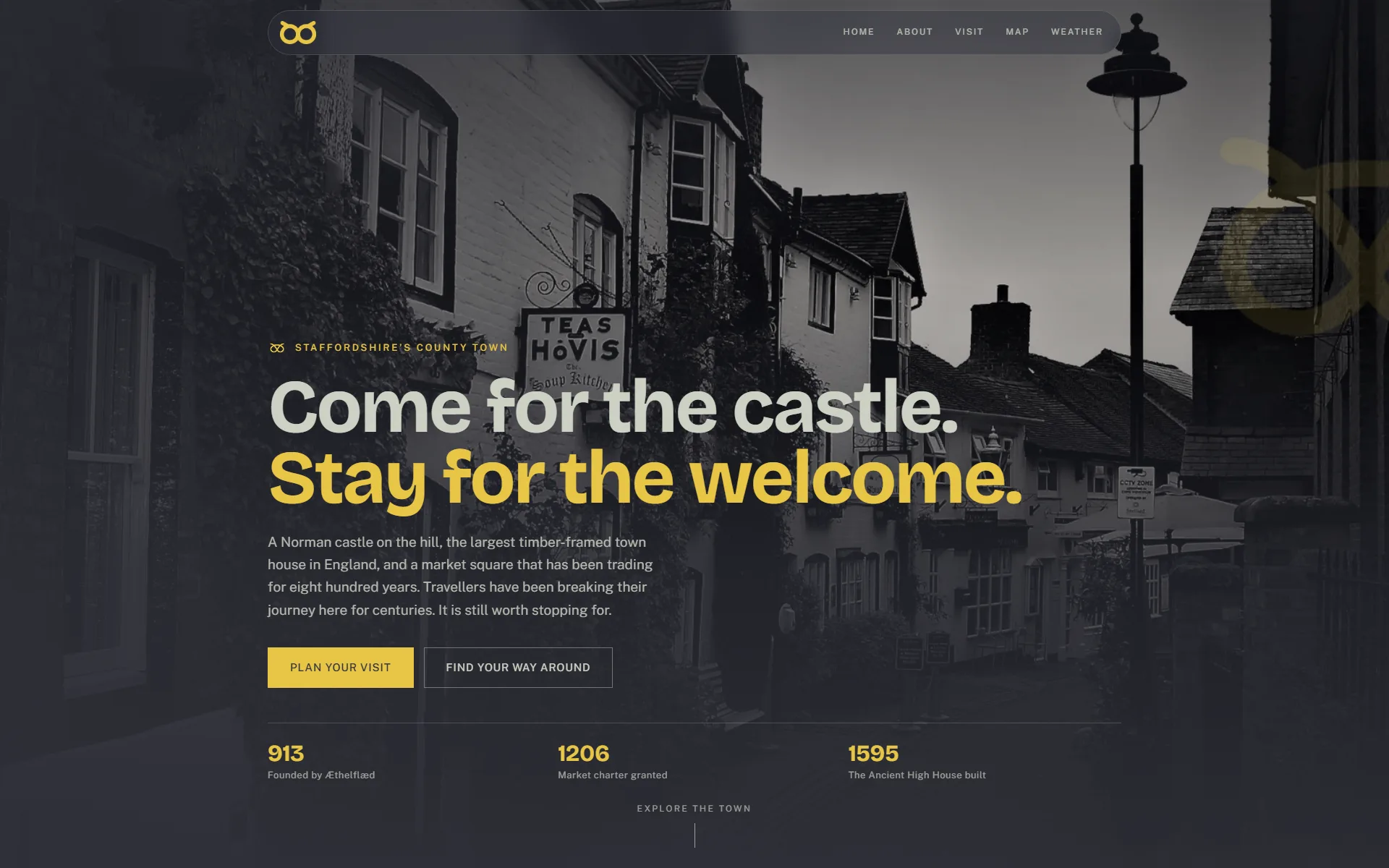 Visit Stafford homepage hero: a black and white photograph of Church Lane behind the headline &lsquo;Come for the castle. Stay for the welcome.&rsquo;, with the second line set in the yellow of the Stafford knot, two buttons, and a row of dates reading 913, 1206 and 1595